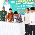Bupati Muba, H.M Toha tengah menandatangani dalam rangka meresmikan pemakaian Balai Serbaguna dan Pos Kamling di Kompleks Griya Randik yang disaksikan oleh perwakilan Forkopimda, Ketua Solidaritas Keluarga Besar Griya Randik, Hairunsyah dan pihak terkait lainnya. (Foto: J)