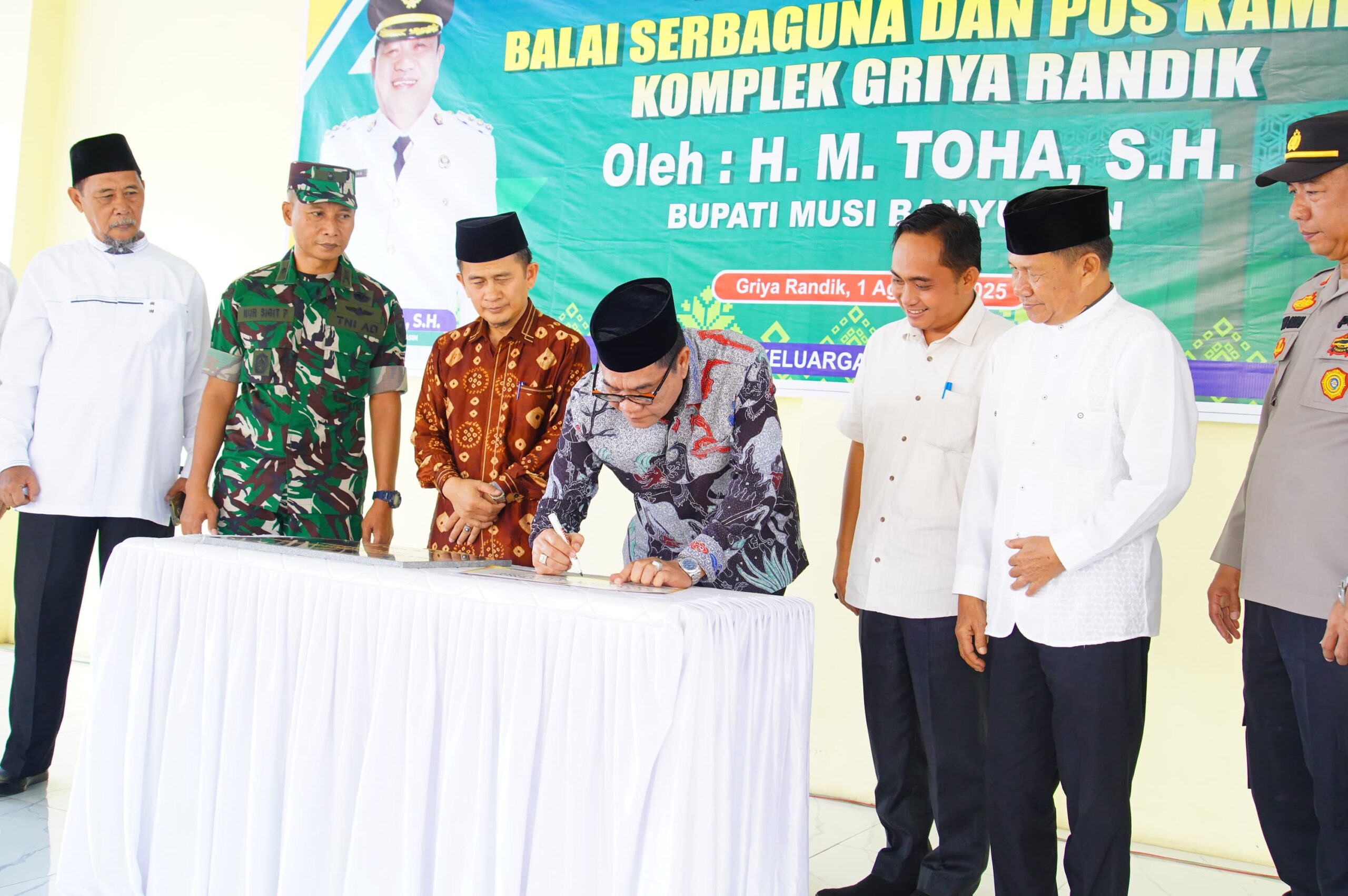 Bupati Muba, H.M Toha tengah menandatangani dalam rangka meresmikan pemakaian Balai Serbaguna dan Pos Kamling di Kompleks Griya Randik yang disaksikan oleh perwakilan Forkopimda, Ketua Solidaritas Keluarga Besar Griya Randik, Hairunsyah dan pihak terkait lainnya. (Foto: J)