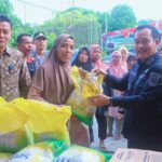 Wabup Muba, Rohman tengah membagikan sembako murah kepada warga Muba melalui Gerakkan Pangan Murah yang didampingi Kadis Ketahanan Pangan, Alibadri.(Foto:J)